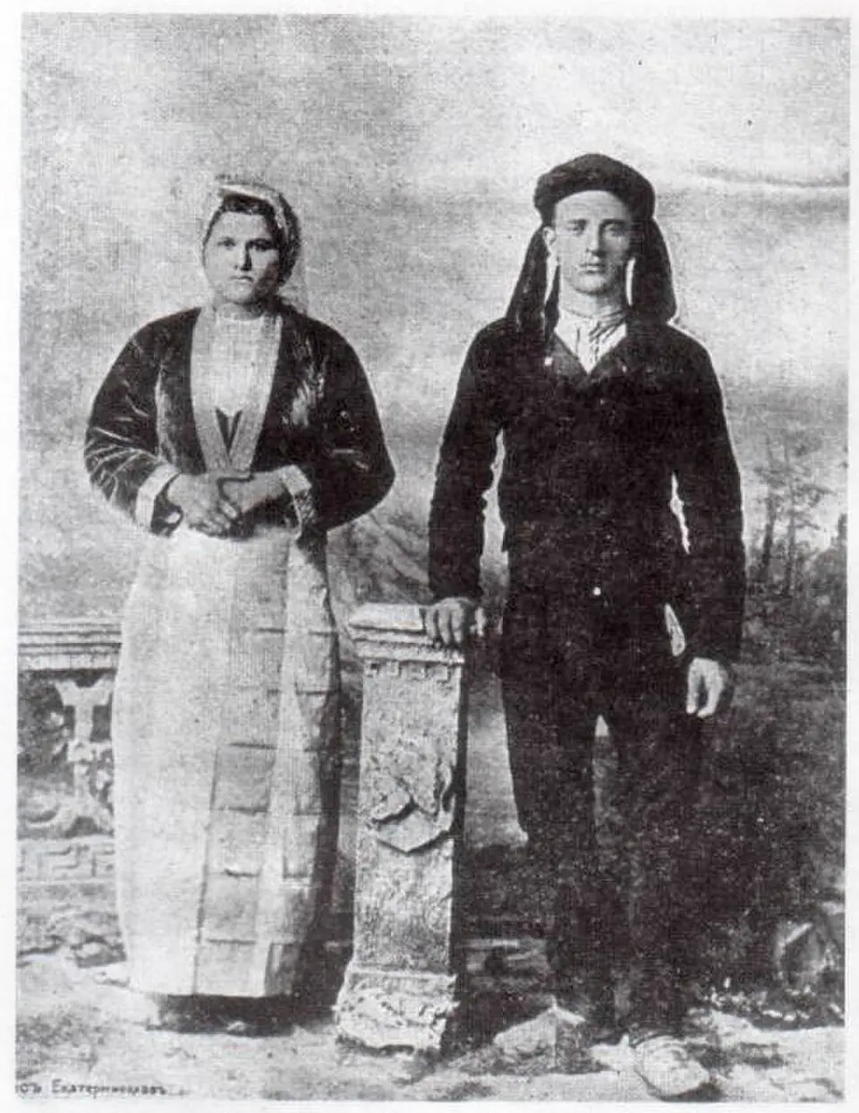A young couple in embroidered folk dress standing either side of a stone pillar - a coarse, grainy black and white newspaper print brought back to natural color